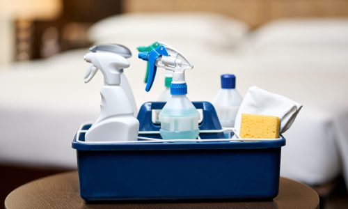 Bucket of products with various disinfectants for cleaning during quarantine. Housekeeping and hygiene concept
