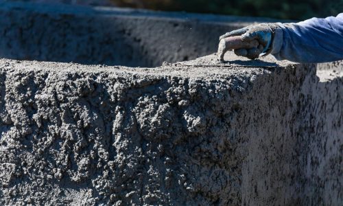 Pool Construction Worker Working With A Smoothing Trowel On Wet Concrete